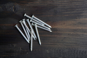 Concrete nails on a black wooden table.                