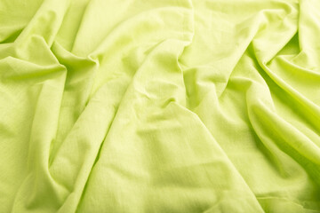 Fragment of green linen tissue. Side view, natural textile background.