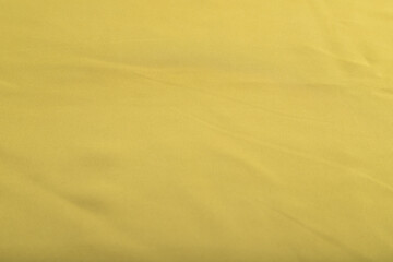 Fragment of smooth green olive silk tissue. Top view, natural textile background.