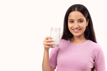 A TEENAGER HOLDING A GLASS OF MILK AND HAPPILY POSING