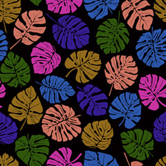 Colorful leaves of the tropical plant monstera. Seamless vector pattern on dark background.