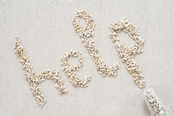 On a gray background, there are seeds in the form of letters and the word "help"