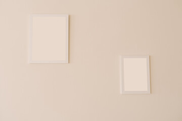 White mockup frames on a beige wall of different sizes