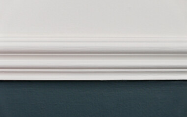 Close up of white dado rail with white above and teal blue green below