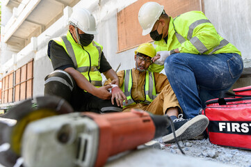 First aid team support to builder worker after hand injury bleeding, accident in work, Using...