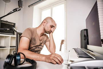 desperate adult man working in home studio when recording software is crashing