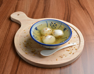 boiled glutinous rice ball (tang yuan) with peanut and sesame in sweet gui Hua flower soup dessert...