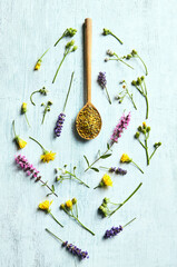 Organic Bee Pollen on a wooden spoon and a lot of wild plants. Flat lay. Healthy lifestyle concept