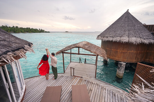 Anonymous couple dancing near ocean in resort