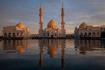 View of the White Mosque of the ancient city Bolgar with a reflection in the water in the evening rays of the setting sun. Bolgar, Republic of Tatarstan, Russia
