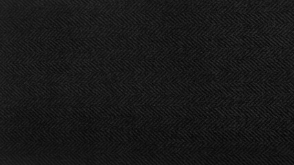 black herringbone pattern fabric, texture background. black and grey tweed pattern, weaving,...