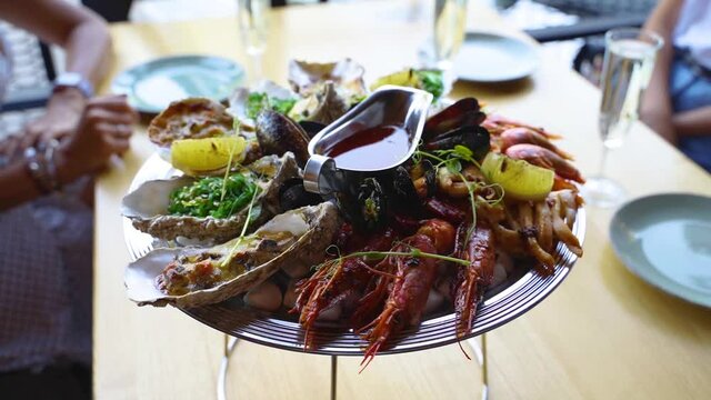 Cooked mixed seafood set salver, lobster shrimp, king prawns, mussels, oysters and squids is served on a table for luxury restaurant visitors. Traditional meditarian dish on tray.