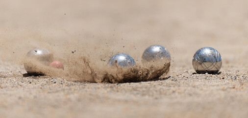 Petanque ball boules bowls on a dust floor, photo in impact. Balls and a small wood jack