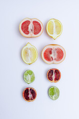 A variety of citrus fruits, cut in half on a white copy space background, top view. Orange, grapefruit, lime and lemon flat lay.