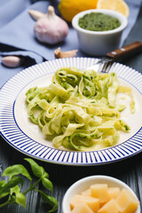 Plate with tasty pesto pasta on table