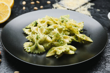 Plate with tasty pesto pasta on table