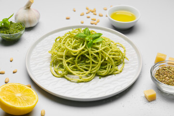 Plate with tasty pesto pasta on grey background