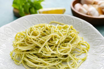Plate with tasty pesto pasta on table, closeup