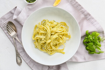 Plate with tasty pesto pasta on white background