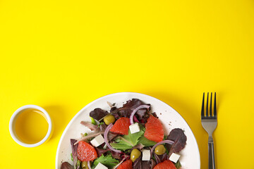 Plate with tasty grapefruit salad on color background, closeup