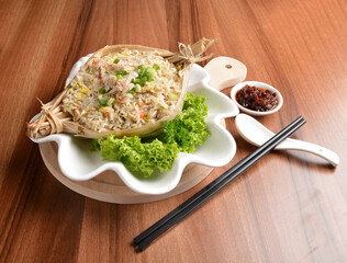 traditional chinese stir egg fried rice with seafood and meat wrapped in leaf on wood table asian halal menu
