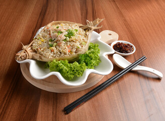 traditional chinese stir egg fried rice with seafood and meat wrapped in leaf on wood table asian halal menu