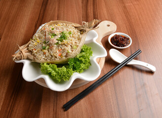traditional chinese stir egg fried rice with seafood and meat wrapped in leaf on wood table asian halal menu
