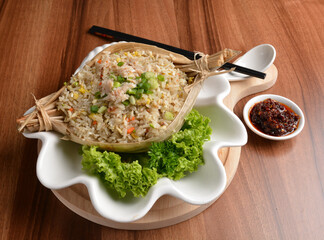 traditional chinese stir egg fried rice with seafood and meat wrapped in leaf on wood table asian halal menu
