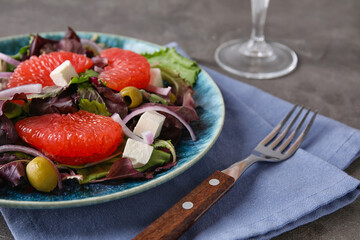 Plate with tasty grapefruit salad on grunge background