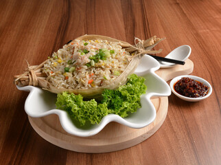 traditional chinese stir egg fried rice with seafood and meat wrapped in leaf on wood table asian halal menu