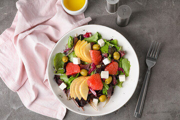 Plate with tasty grapefruit salad on grunge background
