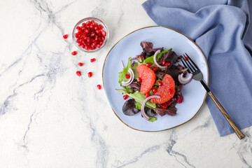 Plate with tasty grapefruit salad on light background