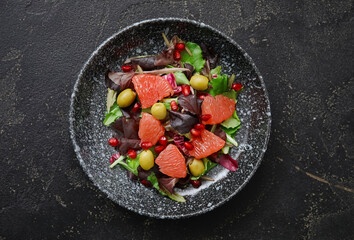 Plate with tasty grapefruit salad on dark background