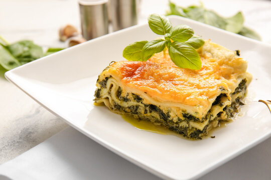 Plate with tasty green lasagna on table, closeup