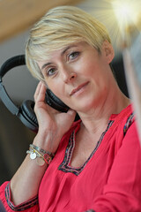 Portrait of a blonde woman listening music with headphones