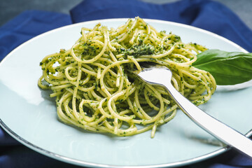 Plate with tasty pesto pasta on table, closeup