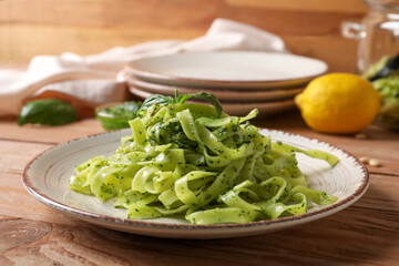 Plate with tasty pesto pasta on table