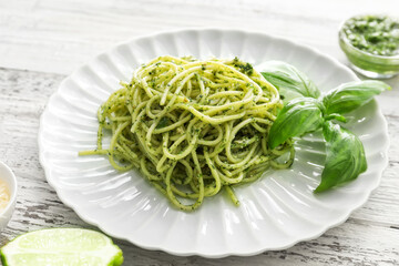 Plate with tasty pesto pasta on table