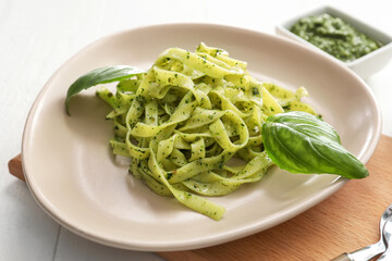 Plate with tasty pesto pasta on table