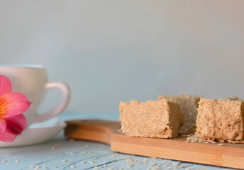 Sesame halva and cup of coffee on blue background. Traditional Middle Eastern sweets. Jewish, Turkish, Arabic national dessert. Turkish delight.A place to copy.