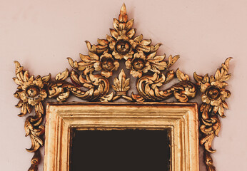 Beautifully handcrafted wooden frame with faded old Thai characters on the wall at Wat Pho
