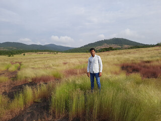 man on a meadow, Indian young man, young man in the wild, people in field. 