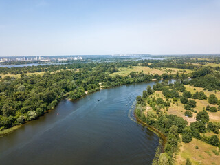 River among green trees in summer. Aerial drone view.