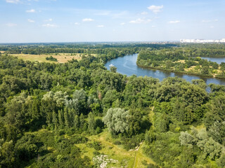 Fototapeta na wymiar Green meadow near the river in summer. Aerial drone view.