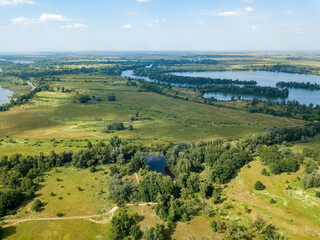 Fototapeta na wymiar Green meadow near the river in summer. Aerial drone view.