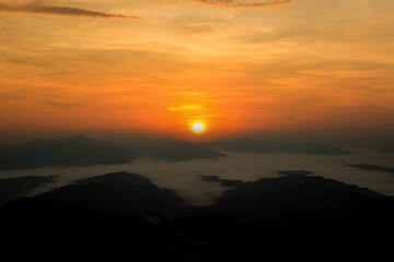 The morning sun and the orange sky above the mountains. Twilight sky background. Colorful Sunset sky and cloud. vivid sky in twilight time background. Fiery orange sunset  Beautiful.