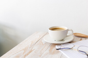 white coffee cup on wooden table with morning light