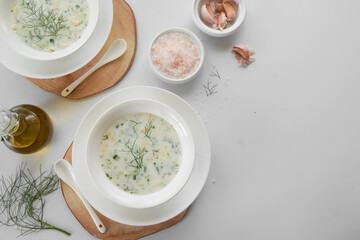 Summer refreshing cold yogurt soup, healthy meal with fresh raw vegetables and dairy ingredients