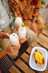 Summer  milkshake. Young friends celebrating summer and drinking milkshakes in a cafe. People, lifestyle, lunch, party, relax concept.