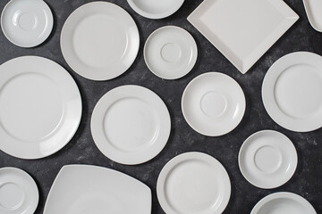 Many white empty plate on black background, close up